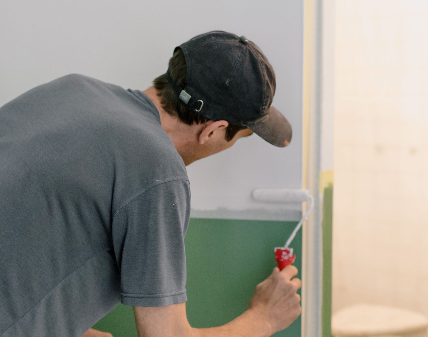 Painter decorator applying paint with a roller in a room