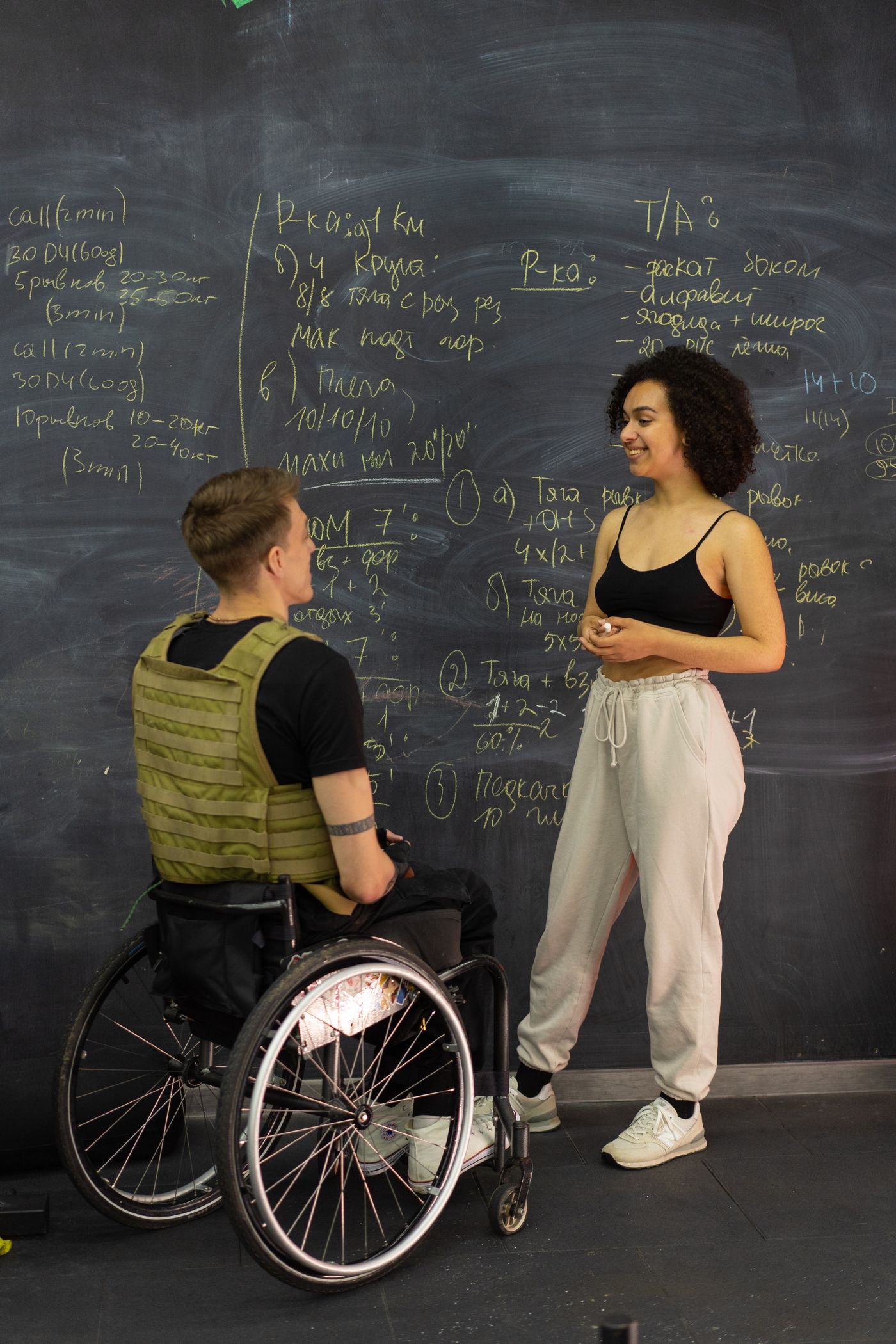 Personal trainer coaching a wheelchair user in a gym